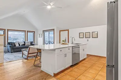 an open kitchen and living room with a couch at Attractive Downtown Condo! Hot Tub, Mountain Views managed by Little Sister Getaways in Canmore