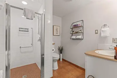 a bathroom with a shower and a toilet and a sink at Attractive Downtown Condo! Hot Tub, Mountain Views managed by Little Sister Getaways in Canmore