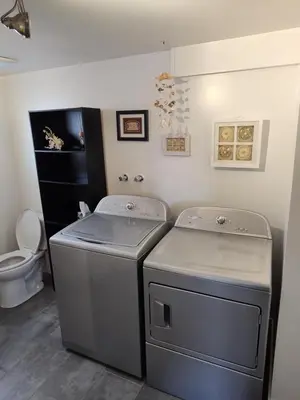 a laundry room with two washers and a toilet at Tranquil & Tasteful One Bdrm Private Suite NE in Edmonton