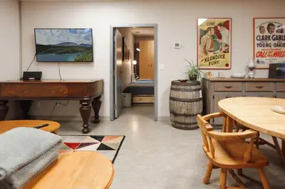 a living room with a piano and a table at The Big Red Barn in Whitehorse