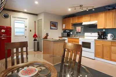 a kitchen with a glass table and wooden cabinets at The Big Red Barn in Whitehorse