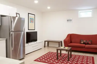 a living room with a refrigerator and a red couch at NN - The Névé - Crestview 1-bed 1-bath in Whitehorse