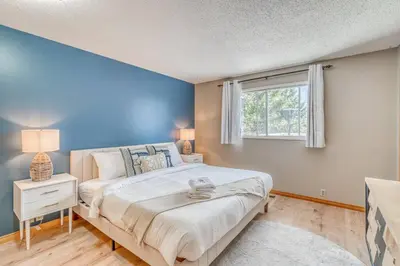 a bedroom with a large bed and a window at Boho Retreat w/King Bed on Bow River Pathway in Calgary