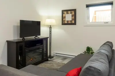 a living room with a couch and a flat screen tv at NN - The Evelyn - Whistlebend 1-bed 1-bath in Whitehorse