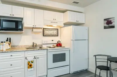 a kitchen with white cabinets and a white refrigerator at NN - The Evelyn - Whistlebend 1-bed 1-bath in Whitehorse