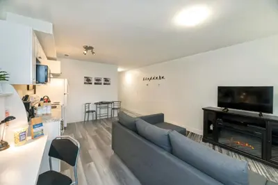 a living room with a blue couch and a fireplace at NN - The Evelyn - Whistlebend 1-bed 1-bath in Whitehorse