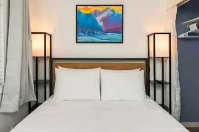 a bedroom with a bed with white pillows and two lamps at NN - The Summit - Copper Ridge 1-bed 1-bath in Whitehorse