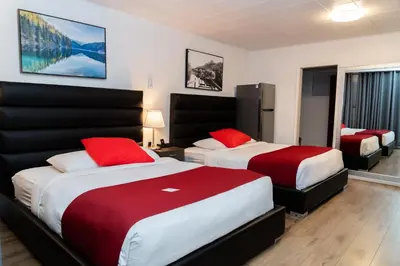 a hotel room with two beds with red pillows at Mountain View Hope Motel in Hope