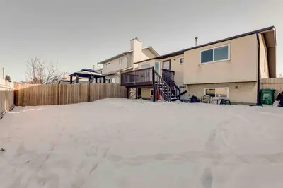 a parking lot with snow in front of a house at Rare Find fully renovated 6 bedroom 3 bath and both levels in Calgary