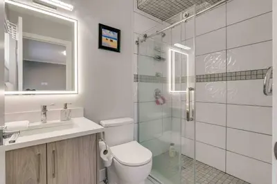 a bathroom with a toilet and a sink and a shower at Rare Find fully renovated 6 bedroom 3 bath and both levels in Calgary