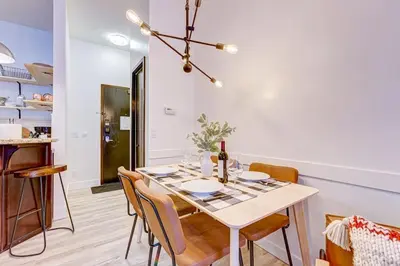a dining room with a white table and chairs at Mountain Retreat, Pool & Hot Tub, BBQ, Patio, King Bed, Sleeps 6! in Canmore