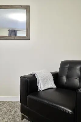 a black leather couch in a living room with a mirror at NN - Eddy #1 - Whistlebend 3-bed 2 5-bath in Whitehorse