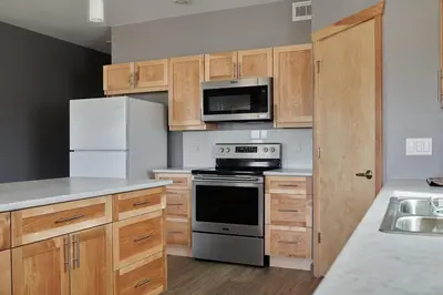 a kitchen with wooden cabinets and a stove and refrigerator at NN - The Kluane - Whistlebend 3-bed 2-bath in Whitehorse