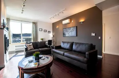 a living room with a leather couch and a table at NN - Park View #2 - Downtown 2-bed 2-bath in Whitehorse