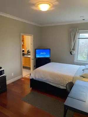a bedroom with a bed and a flat screen tv at independent entrance cozy room with private bathroom close to YVR Richmond in Richmond