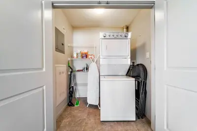 a small kitchen with a refrigerator and a dishwasher at Bright Luxe Condo, AC, Top Floor, King Bed, Balcony! in Edmonton