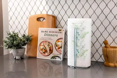 a book sitting on a table next to a paper towel at Peaceful Oasis Condo, AC, Top Floor, Secure UG Parking, Balcony, King Bed! in Edmonton