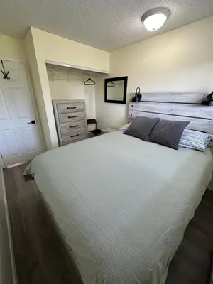 a bedroom with a large white bed and a white door at Lovely 2 bedroom condo, 2 minute walk fr downtown in Invermere