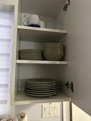 a cabinet filled with plates and dishes in a kitchen at Lovely 2 bedroom condo, 2 minute walk fr downtown in Invermere