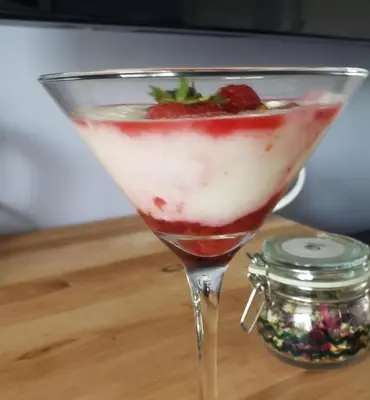a martini glass with a strawberry on a table at Global Village Permaculture BnB in Oliver