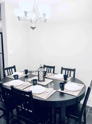 a black table with chairs and plates and a light at 2 BDRM A/C Condo w/Ensuite Laundry + Free Parking in Edmonton