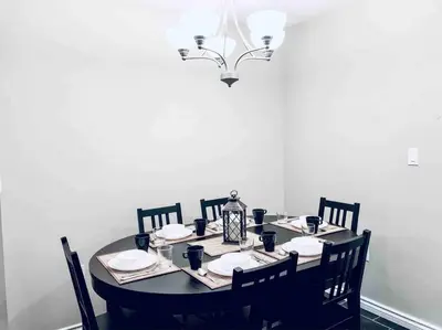 a dining room table with chairs and a lamp at 2 BDRM A/C Condo w/Ensuite Laundry + Free Parking in Edmonton