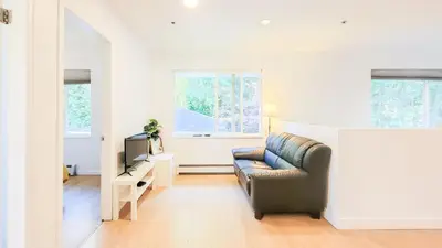 a living room with a couch and a television at Ocean Park B&B in Surrey