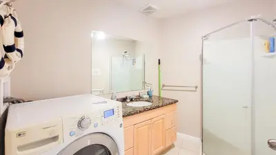 a washing machine in a bathroom with a sink at Ocean Park B&B in Surrey