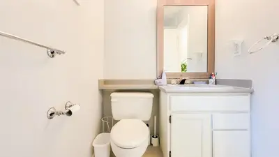 a bathroom with a toilet and a sink and a mirror at Ocean Park B&B in Surrey