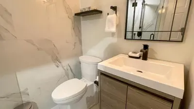 a bathroom with a white toilet and a sink at 2BR plus Loft, Modern and Spacious, Hot Tub and Sauna, Private Balcony, Fireplace in Whistler