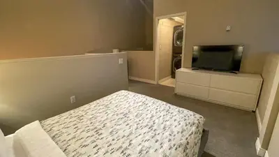 a bedroom with a bed and a flat screen tv at 2BR plus Loft, Modern and Spacious, Hot Tub and Sauna, Private Balcony, Fireplace in Whistler