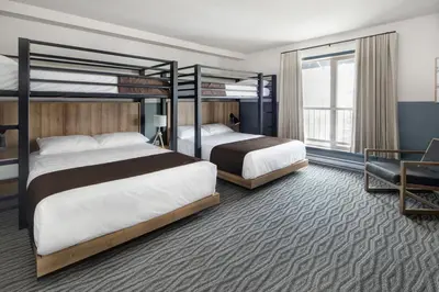 a hotel room with two beds and a chair at The Approach Hotel in Panorama