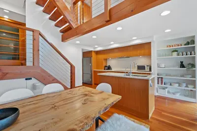 a kitchen with a wooden table and white chairs at Whistler 'Treehouse' in Whistler