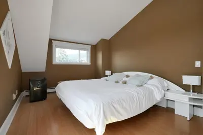 a bedroom with a large white bed and a window at Great West Vancouver house with hot tub, across from beach & 10 mn to Downtown Vancouver in West Vancouver