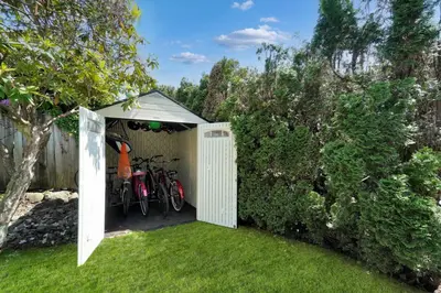 a white shed with two bikes in it at Great West Vancouver house with hot tub, across from beach & 10 mn to Downtown Vancouver in West Vancouver