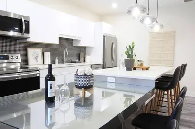 a kitchen with a table with a bottle of wine at Executive Bsmt Suite, King Bed, 5 min to DT & Whyte Ave, Sleeps 6! in Edmonton