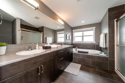 a bathroom with two sinks and a large mirror at Amazing Luxe Home, AC, HUGE Yard, FirePit, Pet Friendly, Sleeps 10! in Edmonton