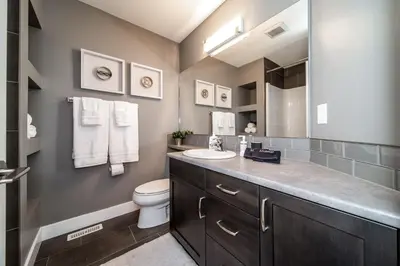 a bathroom with a sink and a toilet at Amazing Luxe Home, AC, HUGE Yard, FirePit, Pet Friendly, Sleeps 10! in Edmonton