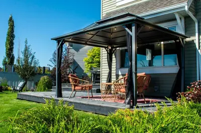 a gazebo on the side of a house at Amazing Luxe Home, AC, HUGE Yard, FirePit, Pet Friendly, Sleeps 10! in Edmonton