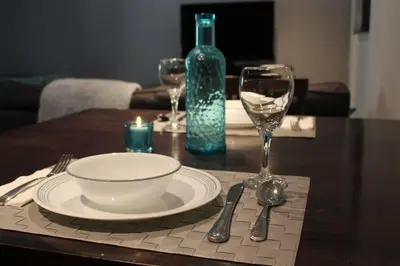 a table with a plate and wine glasses and a bottle at 2-Bedroom basement suite with a separate entrance. in Abbotsford