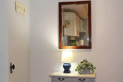 a table with a lamp and a mirror on a wall at 2-Bedroom basement suite with a separate entrance. in Abbotsford