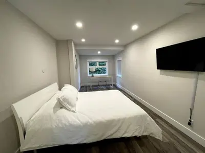 a bedroom with a white bed and a flat screen tv at Escape to Spring Gate Estate in Victoria