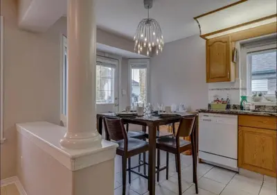 a kitchen with a table with chairs and a chandelier at Big family home w/ Deck, Ping Pong, BBQ & Garage in Edmonton