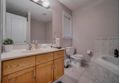 a bathroom with a sink and a toilet and a tub at Big family home w/ Deck, Ping Pong, BBQ & Garage in Edmonton