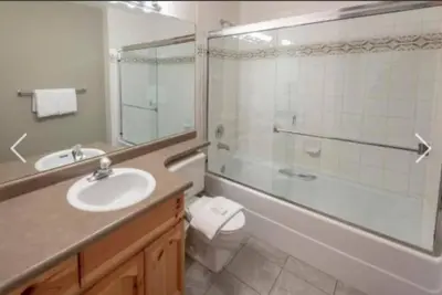 a bathroom with a sink and a toilet and a shower at Whistler Steps to Village Sleeps 8 + Jacuz + Park in Whistler