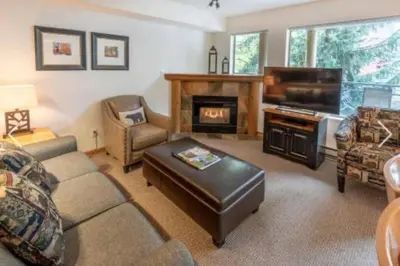 a living room with a couch and a piano at Whistler Steps to Village Sleeps 8 + Jacuz + Park in Whistler