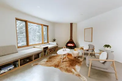 a living room with a couch and a fireplace at Okt Häus in Nordegg