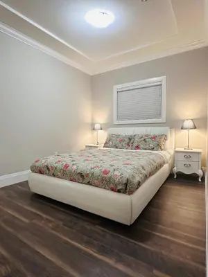 a bedroom with a large bed and two night stands at \u9ce5\u5de22\u7761\u623f\u6c11\u5bbf in Richmond