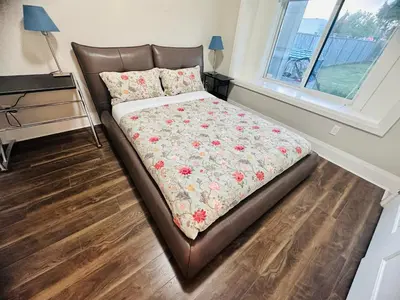 a bedroom with a bed with a floral comforter and a window at \u9ce5\u5de22\u7761\u623f\u6c11\u5bbf in Richmond