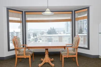 a dining room with a table and chairs and a window at Prime Hotel in Fort McMurray